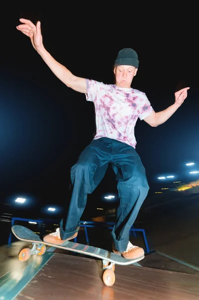 Egy fiatal korcsolyázó egy éjszakai skatepark csinál egy félcső ugrás. Ifjúsági kultúra Szabadidős koncepció éjszaka — Stock Fotó