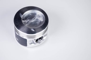 Yeni içten yanmalı motor pistonunun gri bir gradyan arka planda yakın plan görüntüsü. İçten yanmalı motorun yeni yedek parçaları kavramı