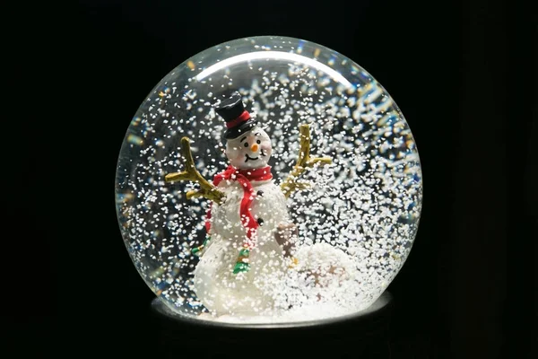 Invierno globo de nieve con muñeco de nieve en negro — Foto de Stock