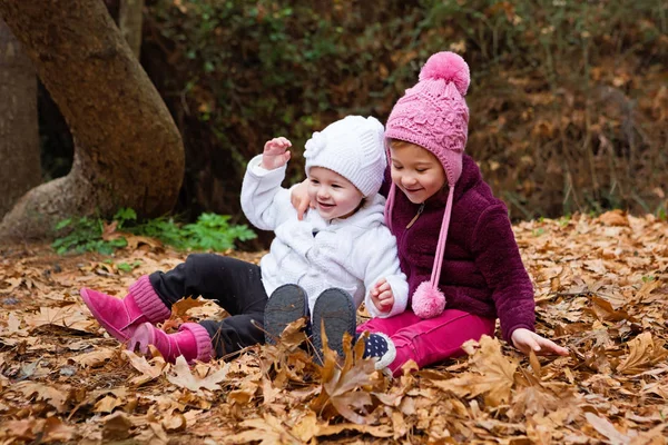 Piccole sorelle che giocano nelle foglie — Foto Stock