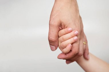 Küçük çocuk Baba'nın elini tutarak