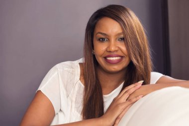 Genç Bayan oturma ve cam kenarında gülümseyen