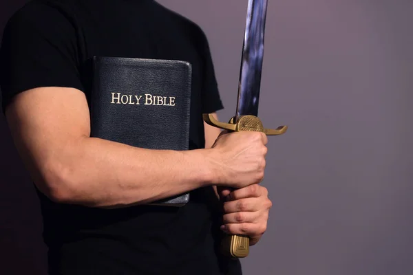 Jonge atletische man met zijn bijbel en zwaard — Stockfoto