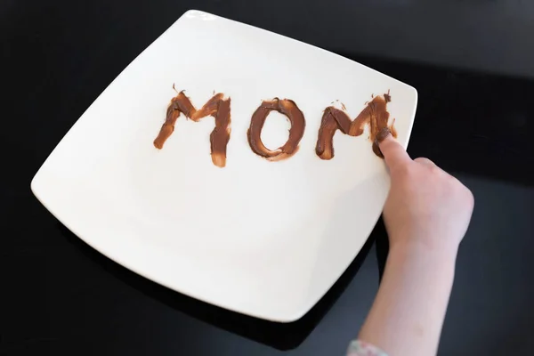 Palavra Mãe Escrito Prato Com Chocolate Espalhado Por Sua Filha — Fotografia de Stock