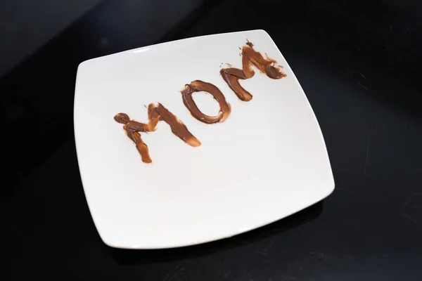 Palabra Mamá Escrita Plato Con Chocolate Difundido Por Hija Pequeña — Foto de Stock