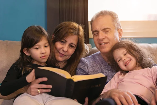 Abuelos Enseñando Sus Nietos Sobre Santa Biblia Fotos De Stock