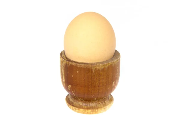 Boiled egg in wooden egg cup isolated on white — Stock Photo, Image