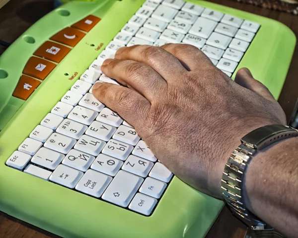 Fechar acima da mão masculina velha no teclado — Fotografia de Stock