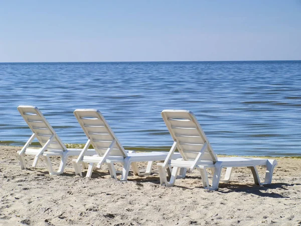 Three sun loungers on a deserted beach — Stock Photo, Image