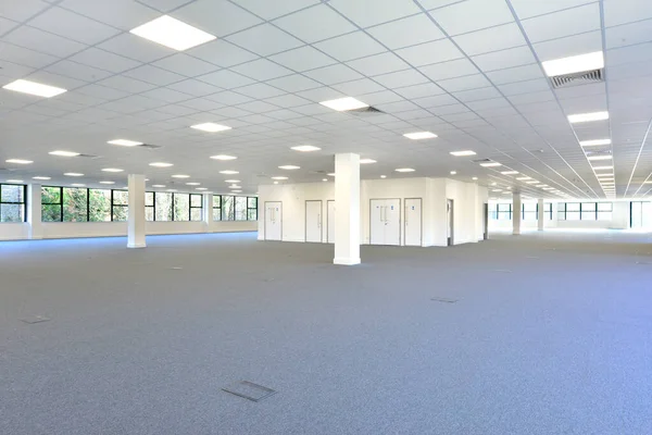 Ein Leerer Bürobereich Mit Grauem Teppich Und Eingeschaltetem Licht lizenzfreie Stockfotos