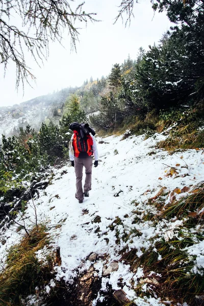 Trekking uomo con neve in montagna — Foto Stock