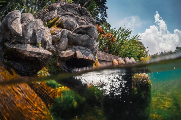 バリ島の水の宮殿 ティルタ ガンガの石の彫刻の水中分割ショット — ストック写真