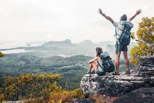 情侣们背着背包在山顶上悠闲自在 欣赏山谷美景 — 图库照片