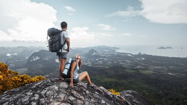 山の上でリラックスし 渓谷の景色を楽しむバックパック付きの観光客のカップル — ストック写真