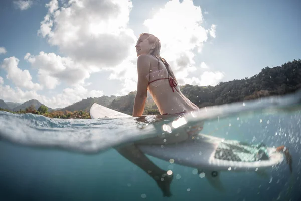 Jonge Vrouw Zittend Surfplank Met Gespleten Onderwater Zicht — Stockfoto