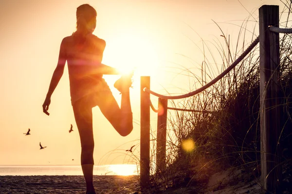 Vrouw Voert Stretching Oefeningen Een Strand Bij Zonsopgang — Stockfoto