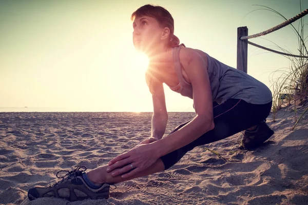 Gün Doğumunda Kumsalda Esneme Egzersizleri Yapan Bir Kadın — Stok fotoğraf