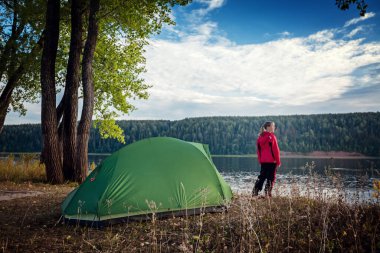 Nehir kıyısındaki çadırda duran bayan.