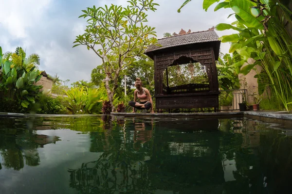 Genç Kadın Havuzun Yanındaki Tropik Bahçede Yoga Egzersizleri Yapıyor — Stok fotoğraf