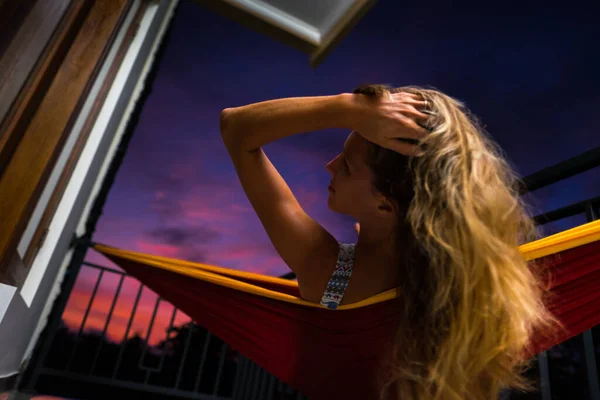 ハンモックでリラックスし バルコニーから夕日を楽しむ女性 — ストック写真