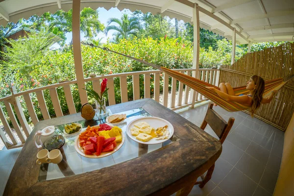 Mesa Con Desayuno Fruta Mujer Relajándose Hamaca Una Terraza Con — Foto de Stock