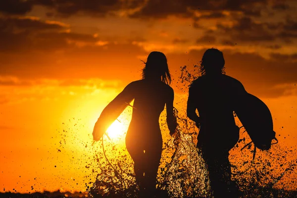 Surferpaar Läuft Bei Sonnenuntergang Mit Brettern Und Vielen Spritzern — Stockfoto