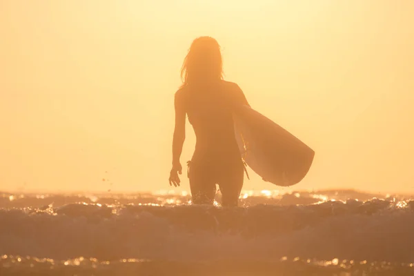 Frau Mit Surfbrett Läuft Bei Sonnenuntergang Aus Dem Meer — Stockfoto