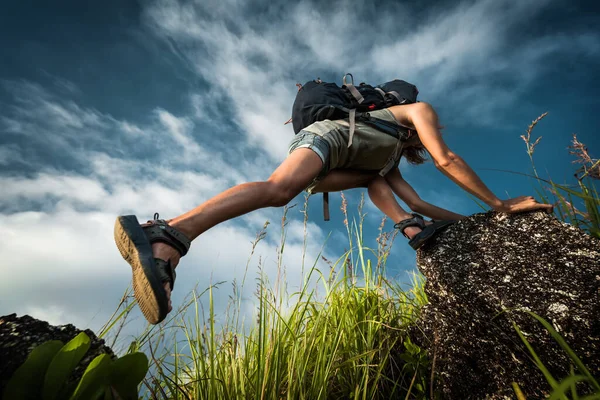 Turista Com Mochila Escalando Uma Rocha Íngreme Sobre Fundo Azul — Fotografia de Stock