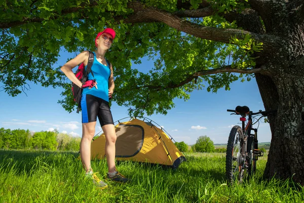 年轻的女士站在绿草如茵的草地上 搭起了一个帐篷 — 图库照片