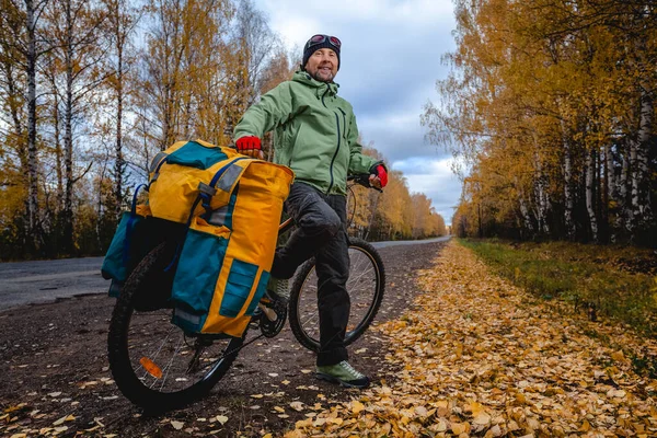 Zralý Bicykl Turista Jeho Naložené Kolo Asfaltu Podzimní Silnici — Stock fotografie