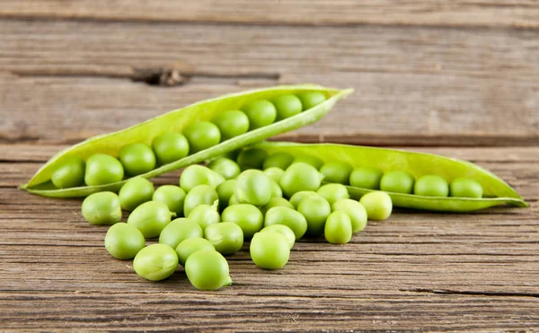 Green peas on wooden background — Stock Photo, Image