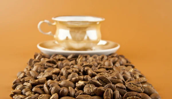 En kopp varmt kaffe och kaffebönor — Stockfoto