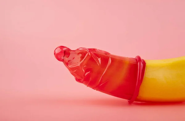 红色的避孕套和一根香蕉 — 图库照片