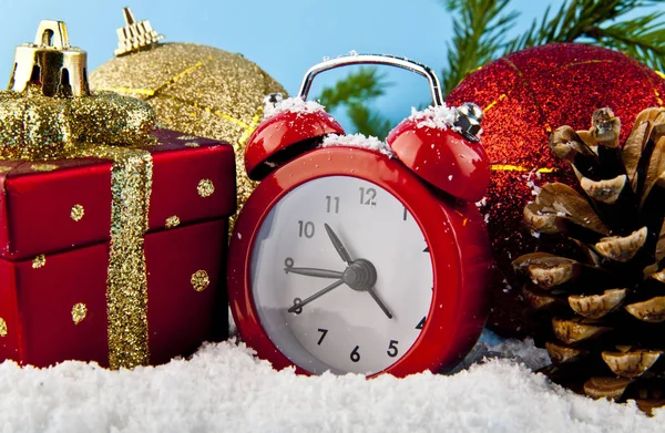 Рождественские подарки часы и белый снег — стоковое фото