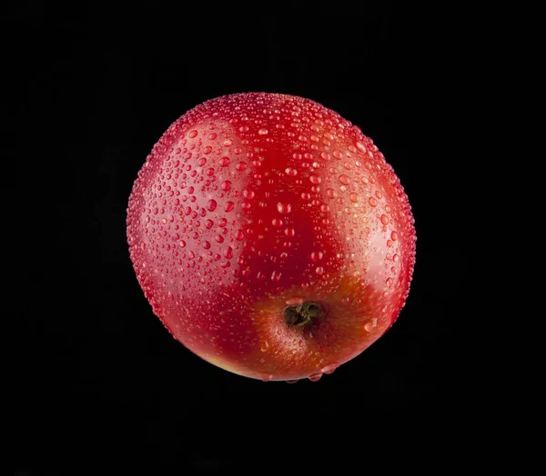 Czerwone jabłko w kropli wody — Zdjęcie stockowe