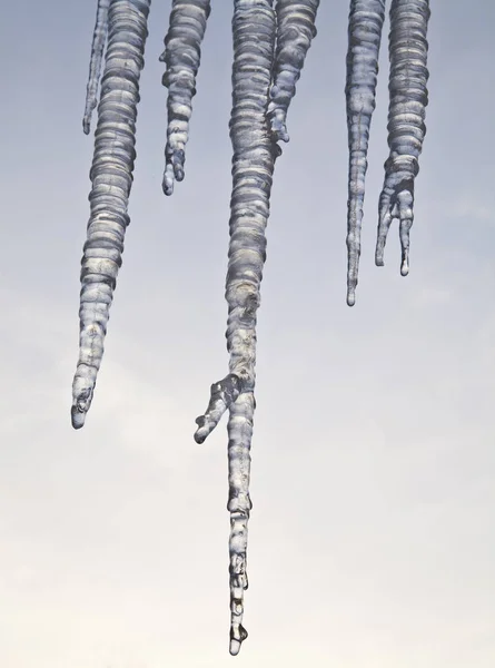 Ice icicles against the sky close-up — стоковое фото