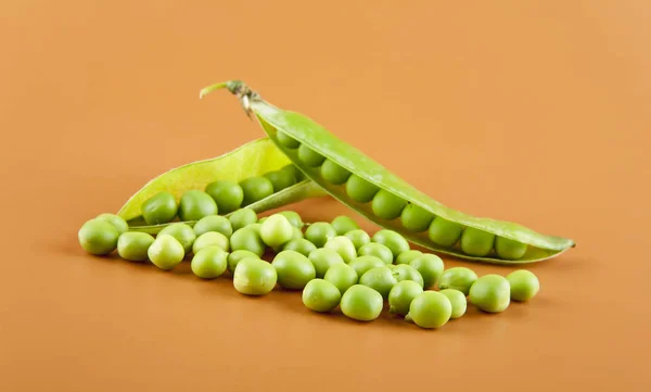 Green peas on a brown background closeup — Stock Photo, Image
