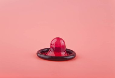 Prezervatif pembe arka plan üzerinde