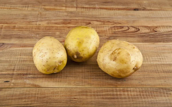 Potatis på en trä bakgrund — Stockfoto