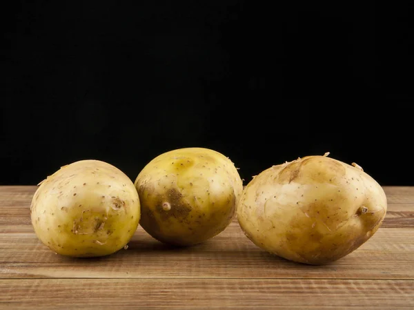 Potatis på en svart bakgrund — Stockfoto