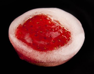 Buz siyah bir zemin üzerine çilek