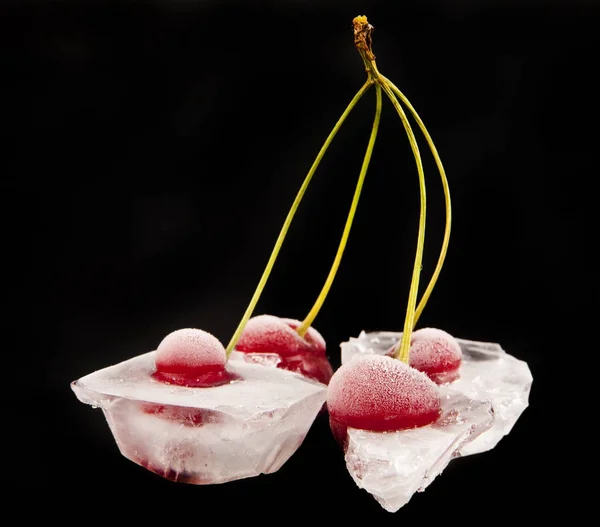 Red cherry in ice on a black background — Stock Photo, Image
