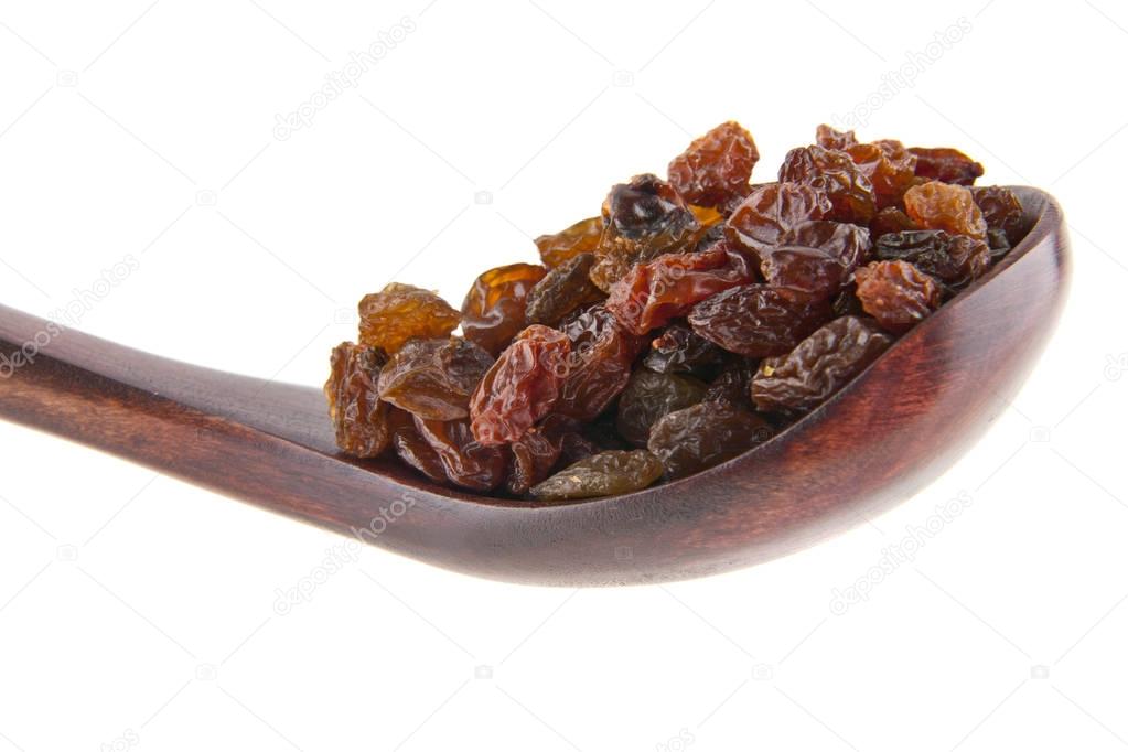 Raisins in a wooden spoon isolated on white background