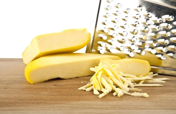 Sýr a struhadlo na dřevěný stůl izolovaných na bílém pozadí — Stock fotografie