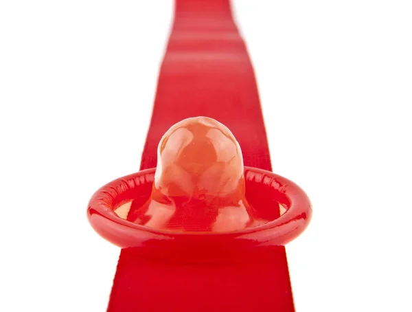 Червона стрічка і презерватив ізольовані на білому тлі крупним планом — стокове фото