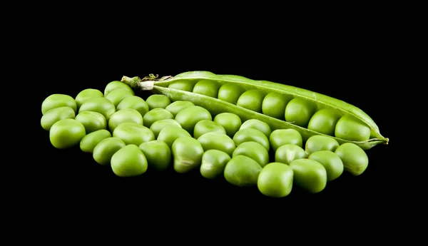 Ervilhas verdes em um fundo preto close-up — Fotografia de Stock