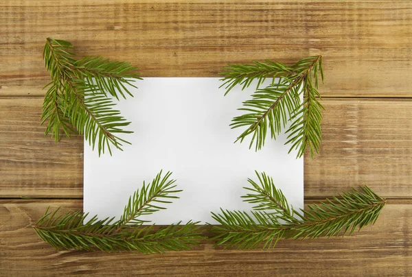 一棵圣诞树的树枝和一张木制 ba 上的纸 — 图库照片
