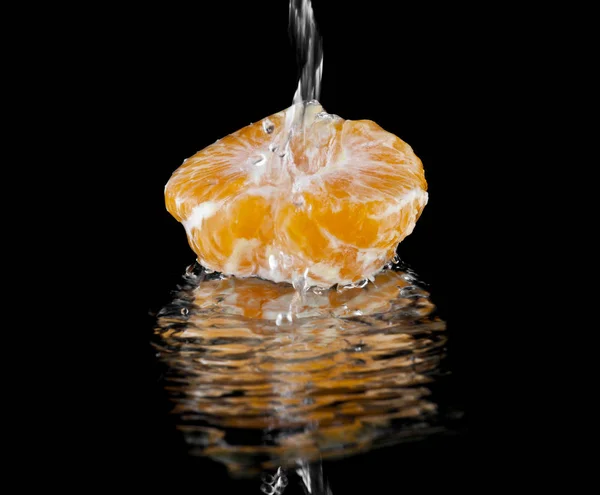 Апельсины в капли воды на черном фоне крупным планом — стоковое фото