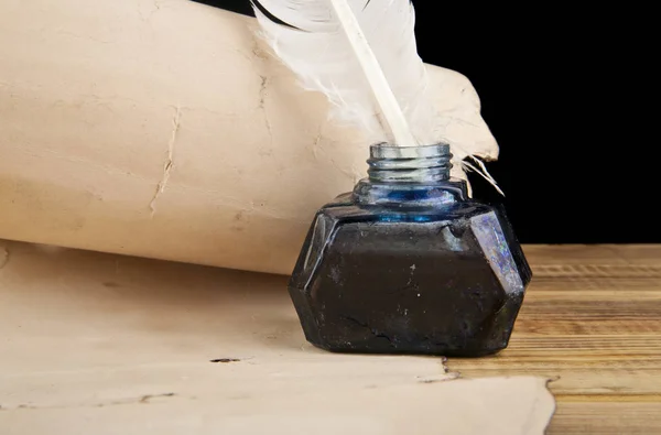 Tintero con una pluma y papel viejo sobre un fondo negro —  Fotos de Stock