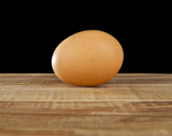 Huevo de gallina sobre un fondo negro — Foto de Stock